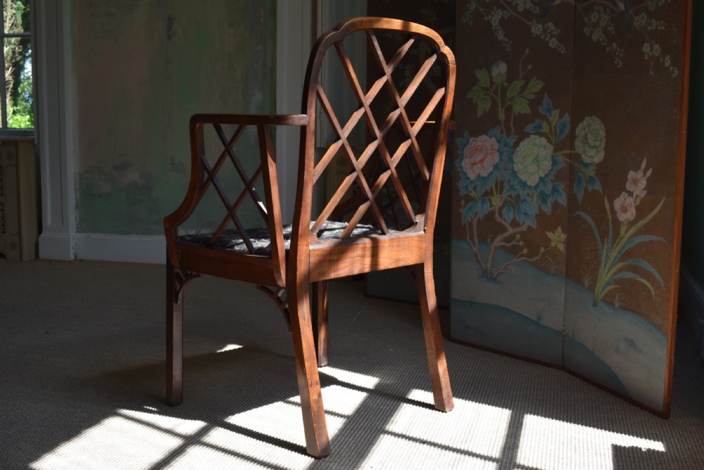 A George III mahogany Cockpen armchair featuring a lattice fretwork backrest, open arms, and a patterned upholstered seat cushion. View VII