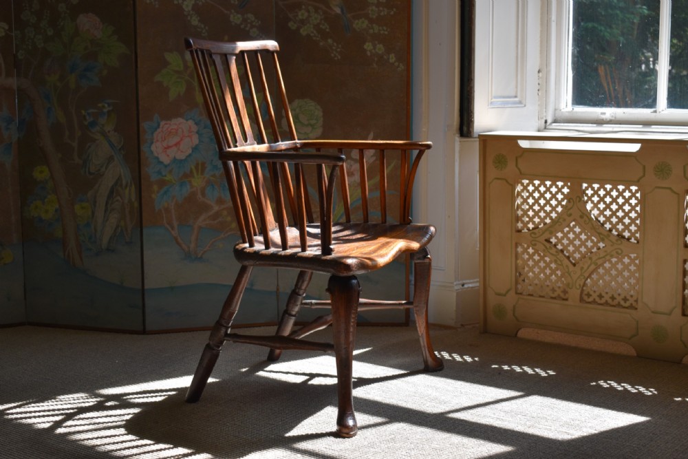 A George III wooden Windsor armchair featuring a shaped saddle seat, comb back rest with splat, and cabriole front legs. View II