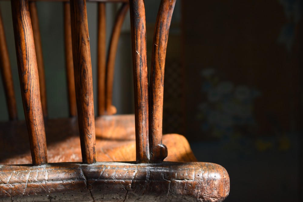 A George III wooden Windsor armchair featuring a shaped saddle seat, comb back rest with splat, and cabriole front legs. View IV