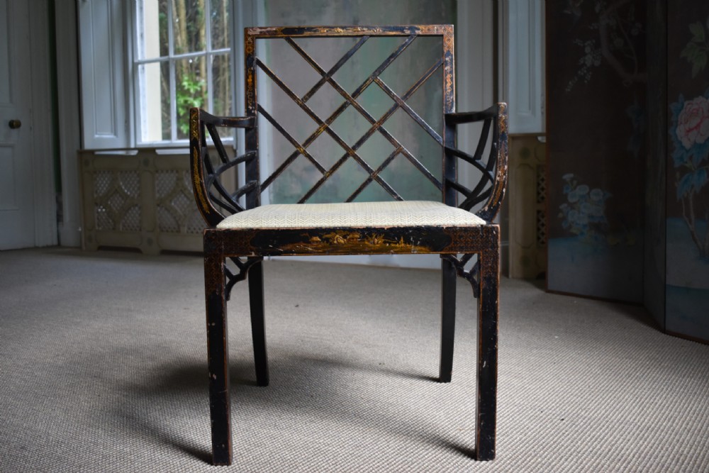 An antique ebonised Chinoiserie Cockpen armchair featuring a dark geometric lattice backrest, fretwork arm supports, straight legs, and a light-coloured fabric seat. View III