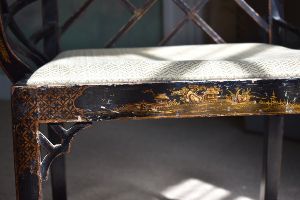 An antique ebonised Chinoiserie Cockpen armchair featuring a dark geometric lattice backrest, fretwork arm supports, straight legs, and a light-coloured fabric seat. View IV
