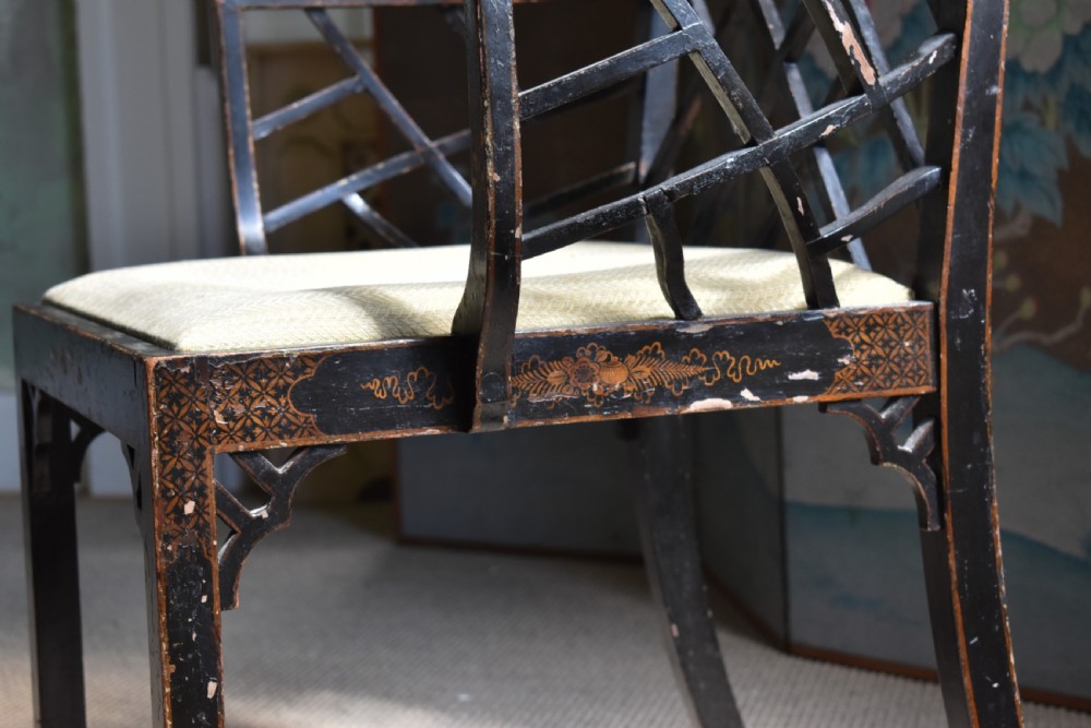 An antique ebonised Chinoiserie Cockpen armchair featuring a dark geometric lattice backrest, fretwork arm supports, straight legs, and a light-coloured fabric seat. View VII