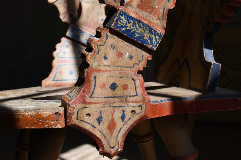 A Swedish folk art wooden armchair with a carved backrest featuring yellow, red, and blue painted details. View V