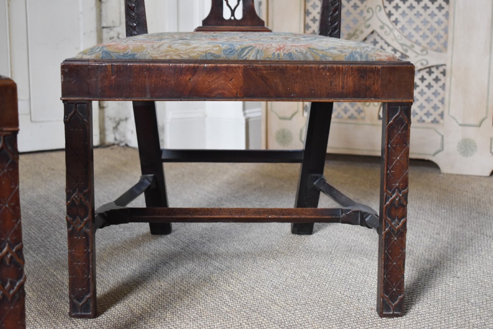 A pair of dark mahogany side chairs with intricate pierced back splats, carved square legs with fretwork, and tapestry fabric seats. View II