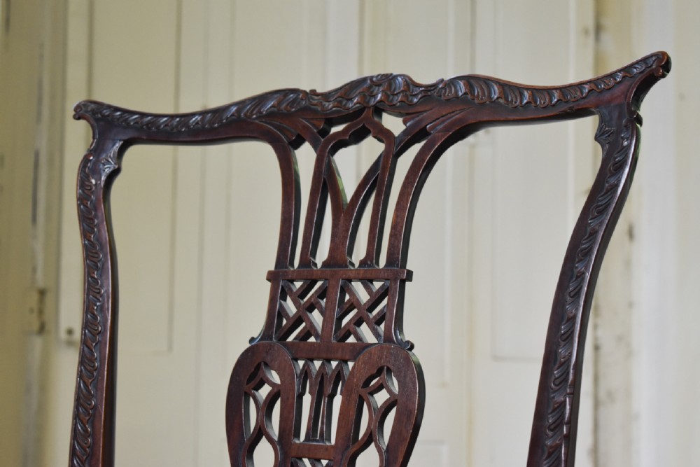 A pair of dark mahogany side chairs with intricate pierced back splats, carved square legs with fretwork, and tapestry fabric seats. View IV