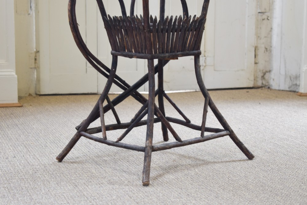 An antique folk art side table crafted from dark bent twigs with decorative notched patterns and arched bracing. View IV