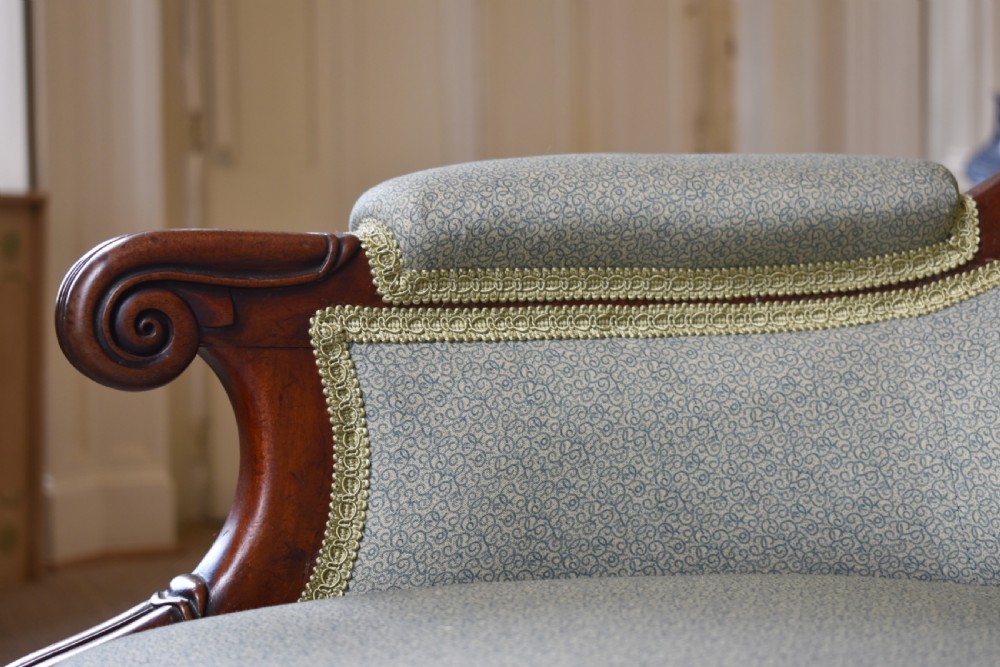 A George IV mahogany armchair with carved scroll arms, light green upholstery, and reeded turned front legs on brass castors. View VI