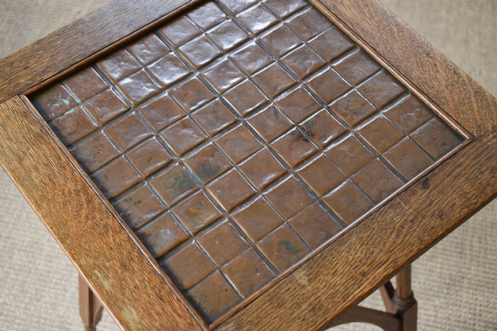 An antique Arts and Crafts oak occasional table featuring a square tiled inset top, arched bracing, and slender turned spindle legs. View III