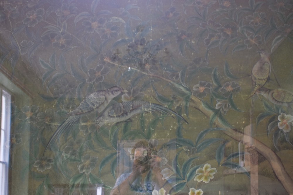 A large nineteenth-century framed Asian wall hanging painted with birds, blooming flowers, and foliage on a muted green background. View X