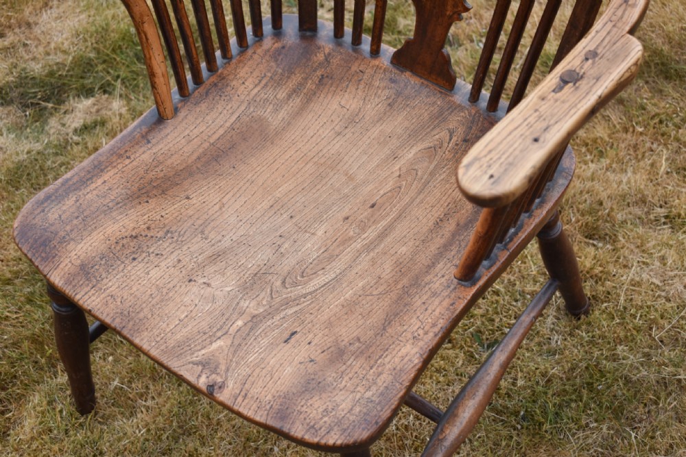A Victorian dark wood Windsor armchair featuring a high backrest with a wheelback splat, steam-bent armrests, turned legs, and an H-stretcher base. View II
