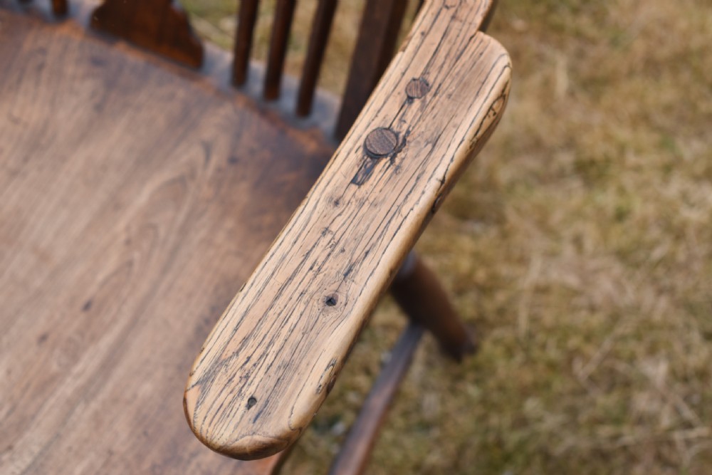 A Victorian dark wood Windsor armchair featuring a high backrest with a wheelback splat, steam-bent armrests, turned legs, and an H-stretcher base. View V