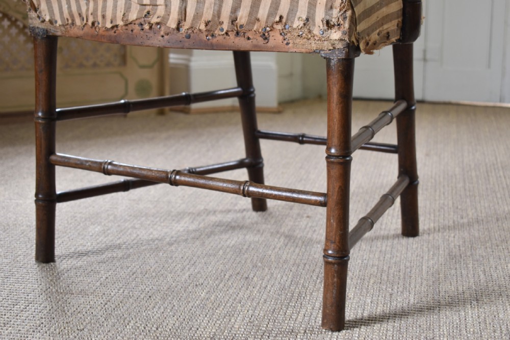 A dark-stained wooden armchair featuring simulated bamboo turnings across the frame and backrest, fitted with a striped fabric seat. View II