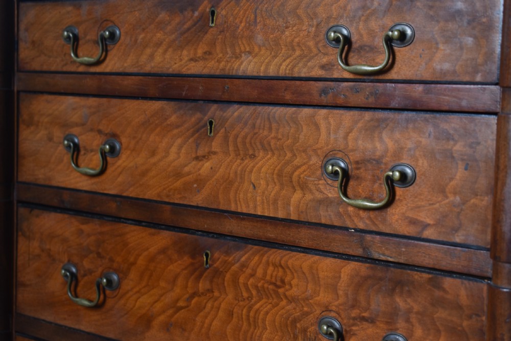 A compact antique mahogany chest of drawers with four graduated drawers, brass handles, and reeded corner details. View II