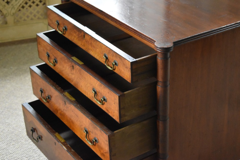 A compact antique mahogany chest of drawers with four graduated drawers, brass handles, and reeded corner details. View IV