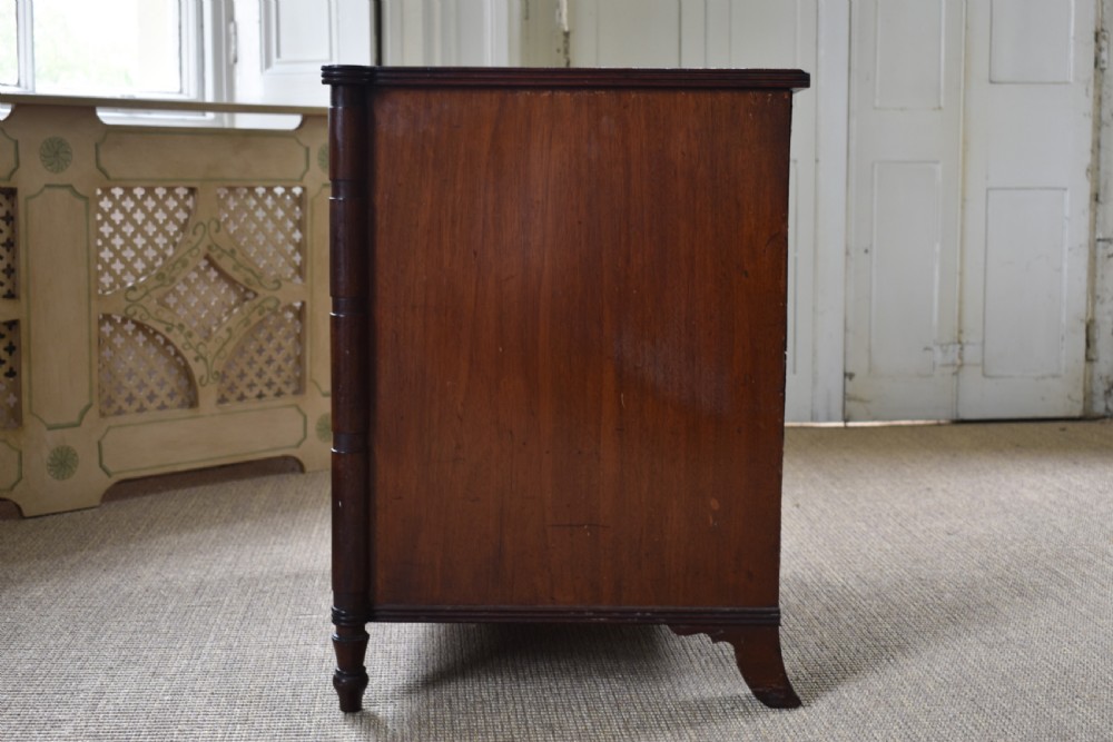 A compact antique mahogany chest of drawers with four graduated drawers, brass handles, and reeded corner details. View V