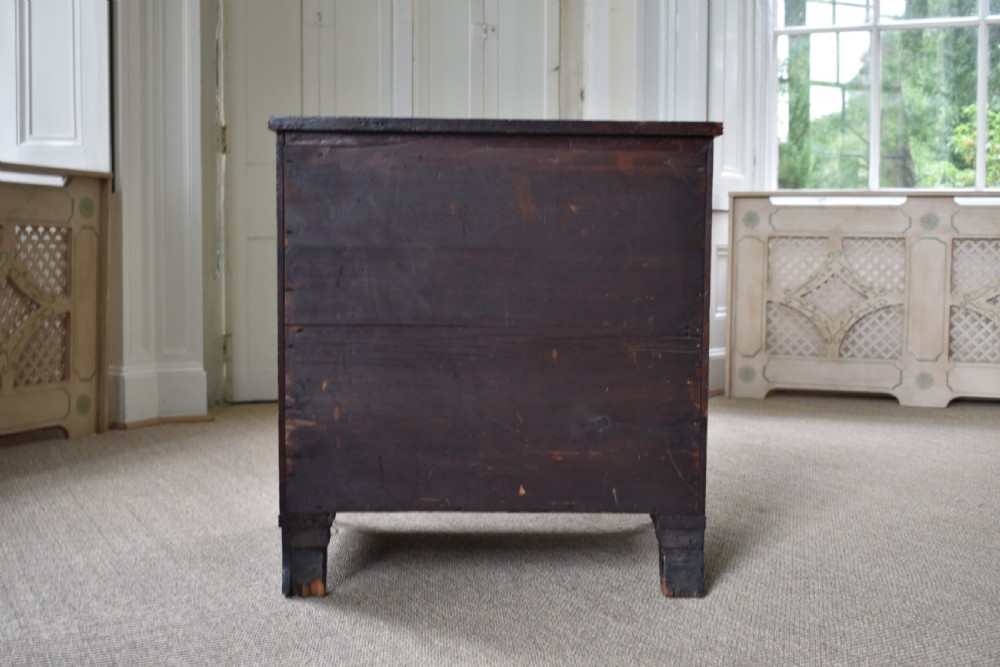 A compact antique mahogany chest of drawers with four graduated drawers, brass handles, and reeded corner details. View VI