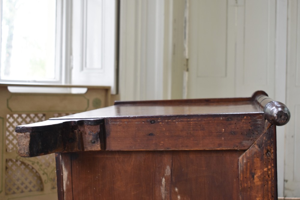 A compact antique mahogany chest of drawers with four graduated drawers, brass handles, and reeded corner details. View VII