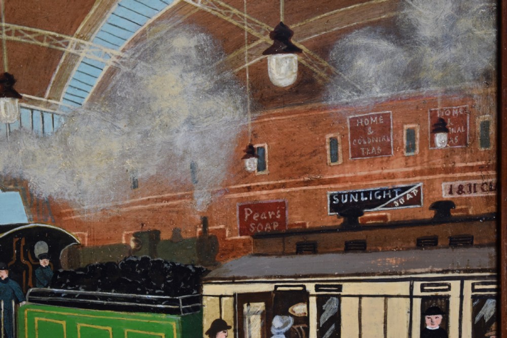 An oil painting on board depicting a busy Victorian steam train station scene inside a heavy bobbin-turned wood frame. View VI