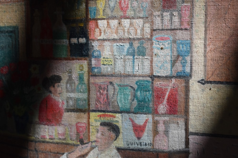 A framed oil on canvas painting depicting a detailed tavern bar interior scene with seated figures, tankards hanging overhead, and a painted pale blue wooden frame. View VI