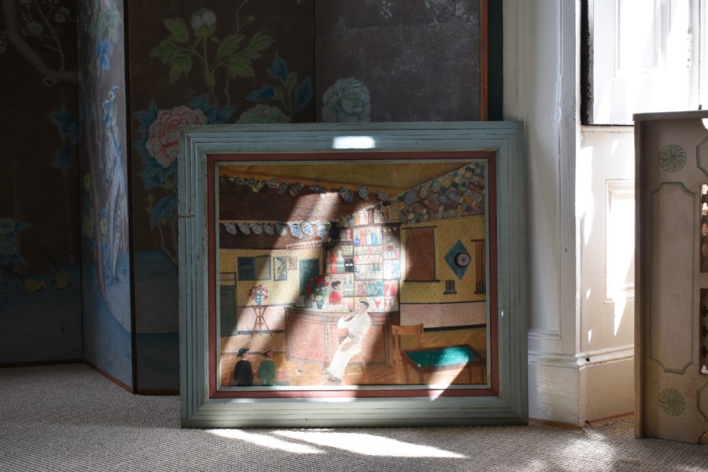A framed oil on canvas painting depicting a detailed tavern bar interior scene with seated figures, tankards hanging overhead, and a painted pale blue wooden frame. View VII