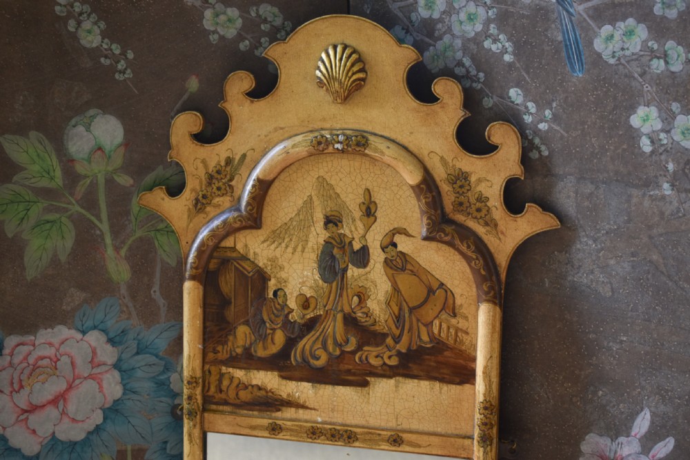 A tall, narrow Queen Anne style mirror featuring an arched frame decorated with chinoiserie hand-painted scenes, a carved gilt shell cresting, and ochre yellow lacquered borders. View II