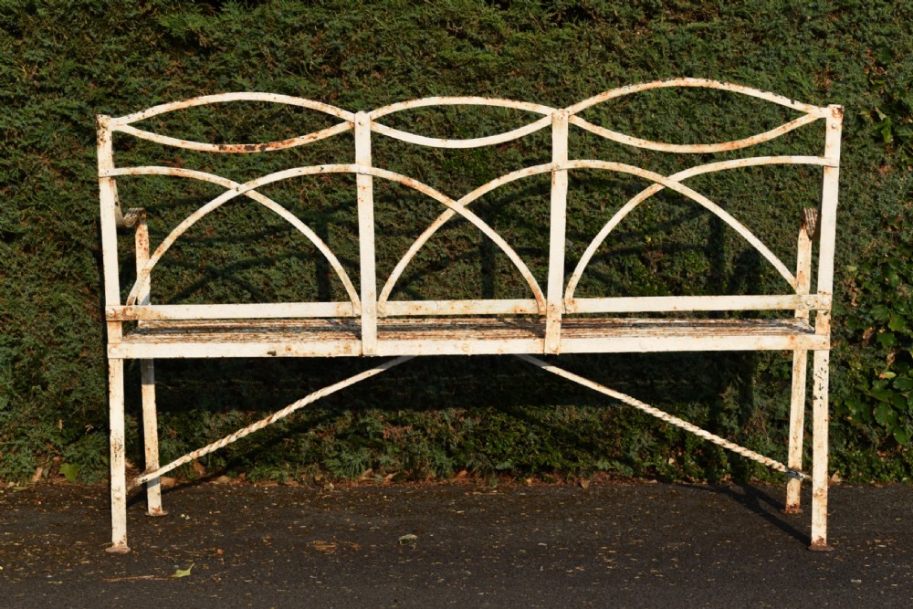 An antique off-white painted wrought iron garden bench featuring arched strapwork back panels and a weathered patina. View VII