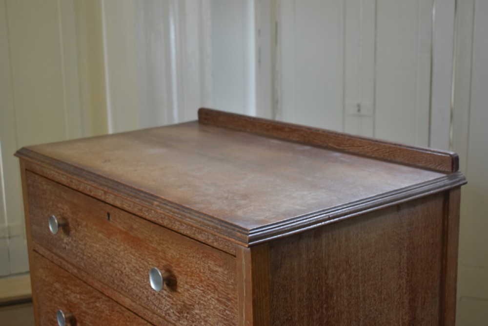 A tall limed oak chest featuring five stacked drawers with small circular turned handles. View IV