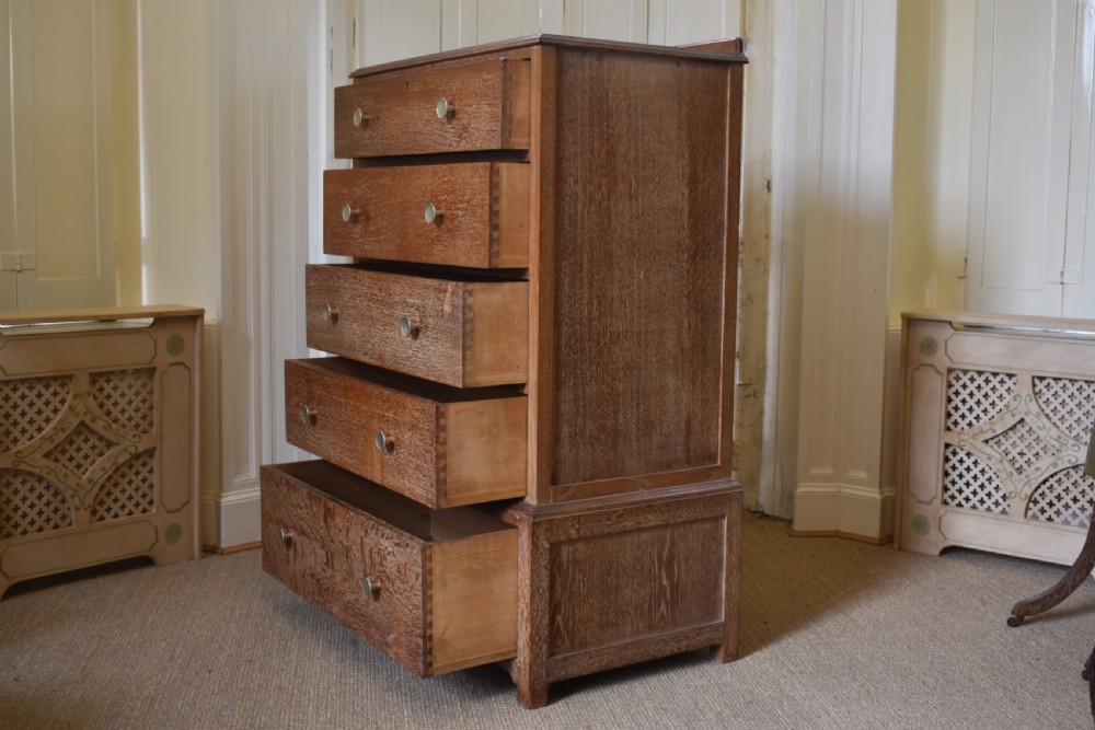 A tall limed oak chest featuring five stacked drawers with small circular turned handles. View V