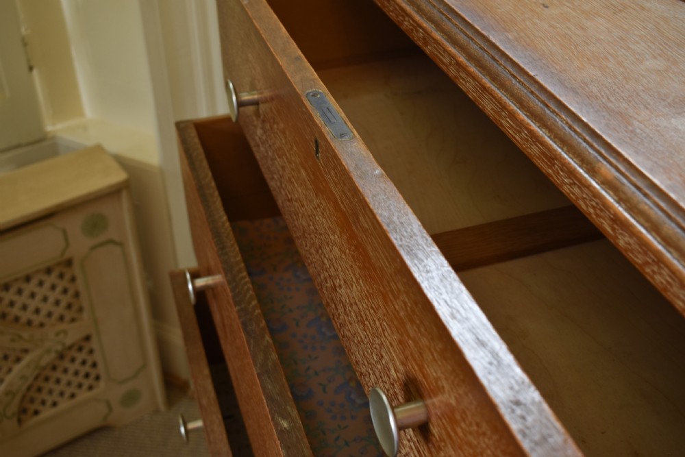A tall limed oak chest featuring five stacked drawers with small circular turned handles. View VI