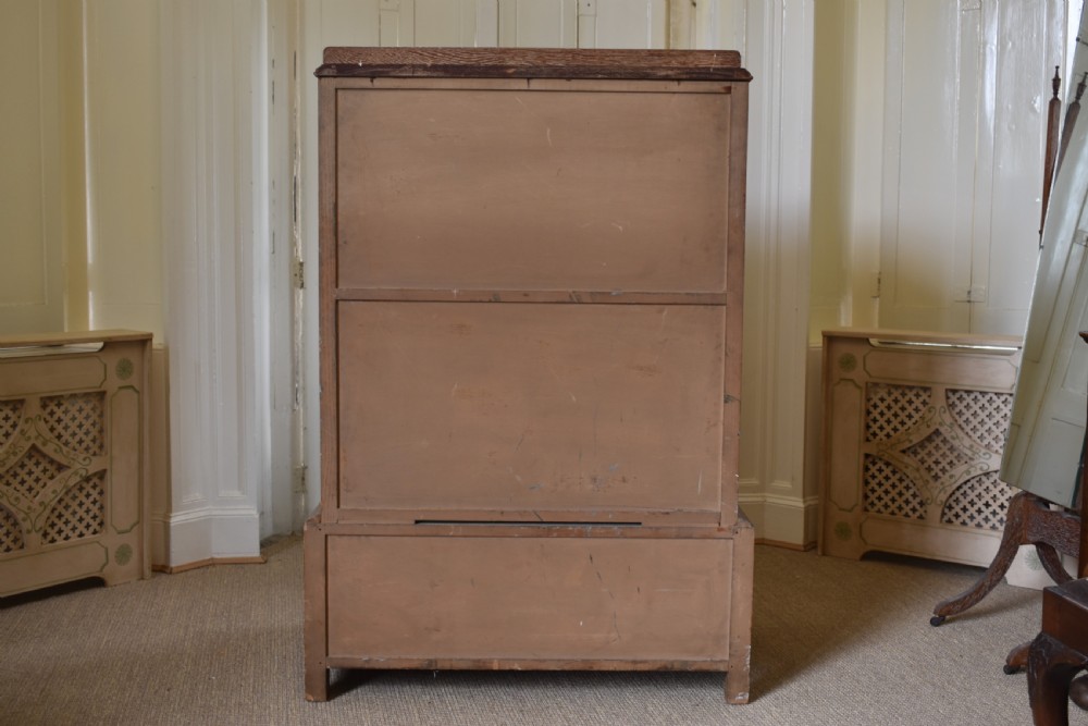 A tall limed oak chest featuring five stacked drawers with small circular turned handles. View VII