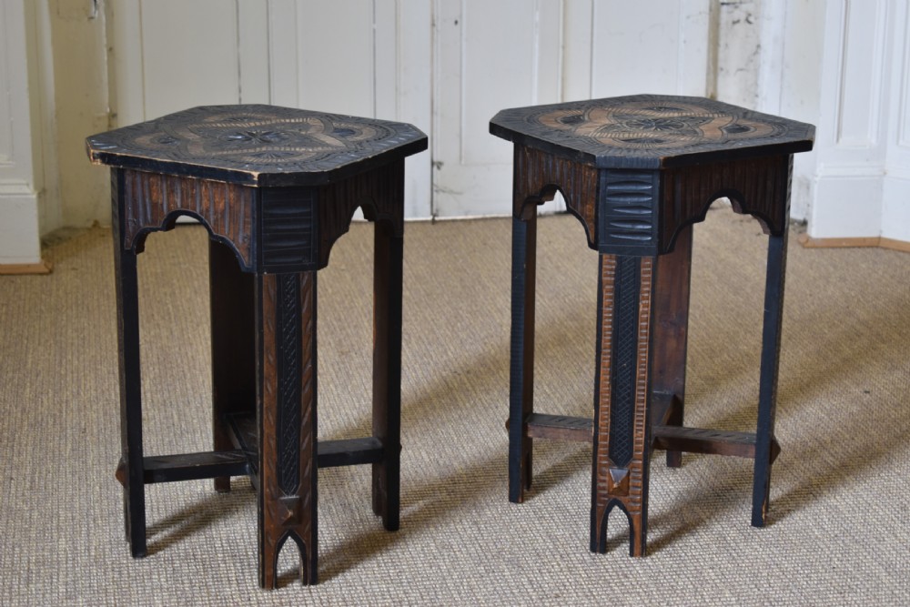 A pair of dark stained timber side tables featuring geometric chip-carved star patterns on the tops and carved legs with cross-stretchers. View II