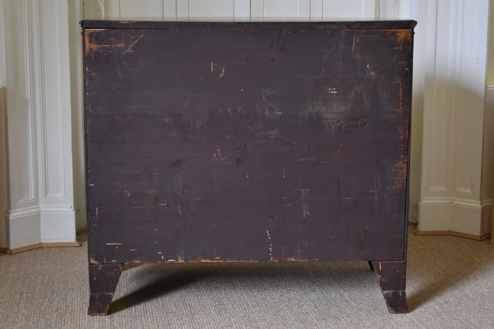 A Georgian flame mahogany bow-front chest of drawers with three open graduated drawers and circular brass handles. View VII
