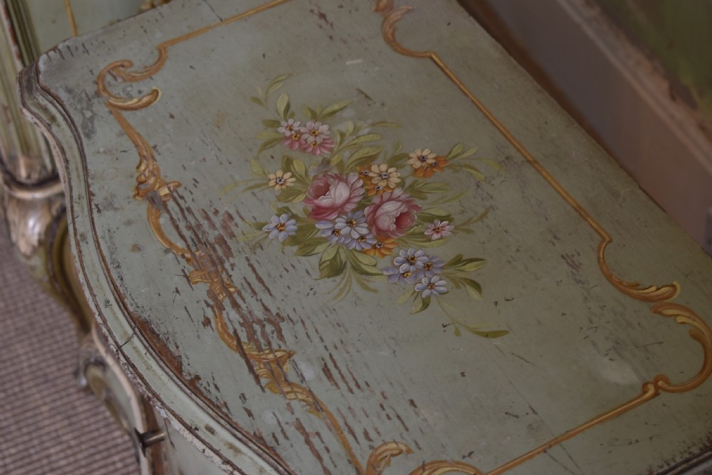 A pair of sage green French painted bedside cabinets with floral hand-painting, gilt scroll mouldings, double doors, and cabriole legs. View V