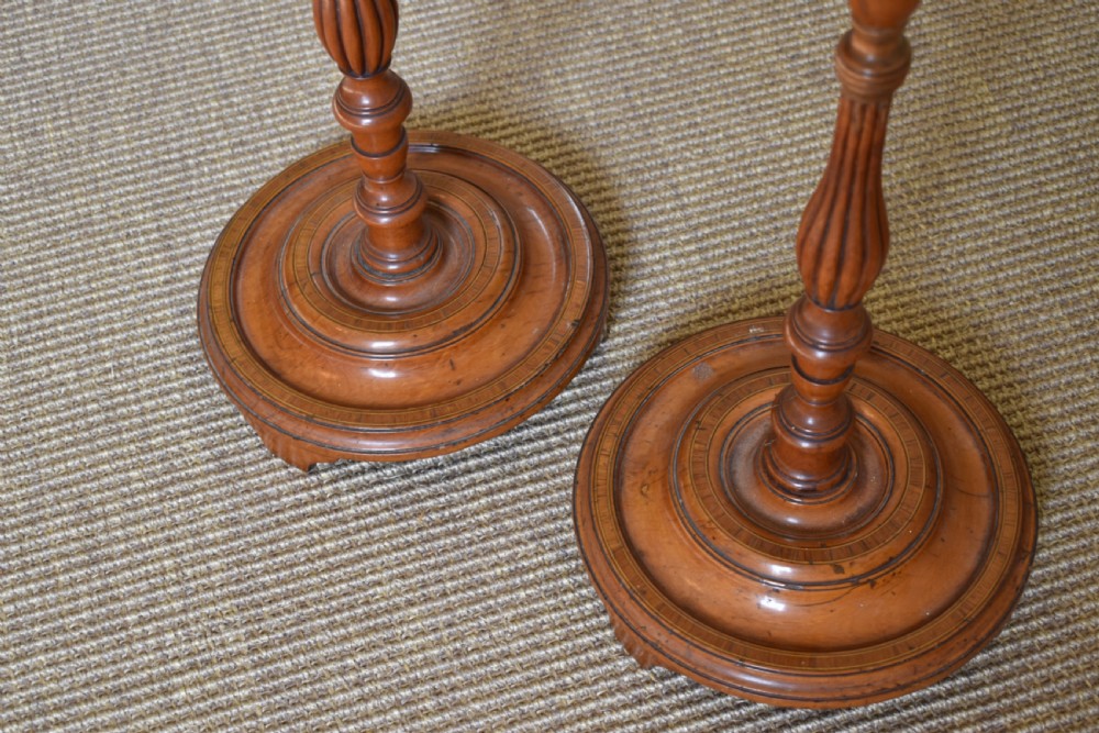 A pair of tall, slender antique satinwood candle stands featuring circular tray tops, fluted turned columns, and circular molded bases. View II
