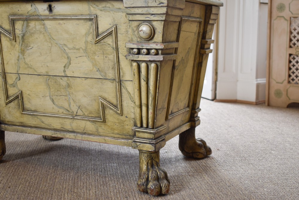 A Regency sarcophagus-form cellaret decorated with faux marble painted timber, fluted corner columns, and carved lion paw feet. View II