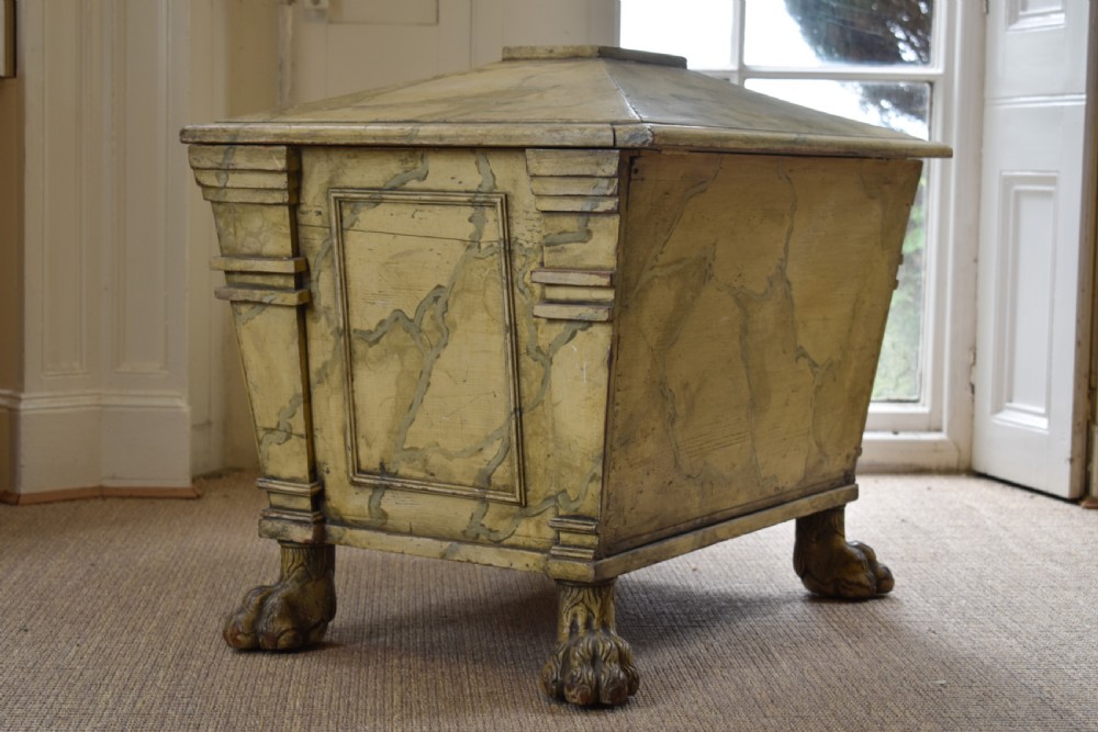 A Regency sarcophagus-form cellaret decorated with faux marble painted timber, fluted corner columns, and carved lion paw feet. View VI