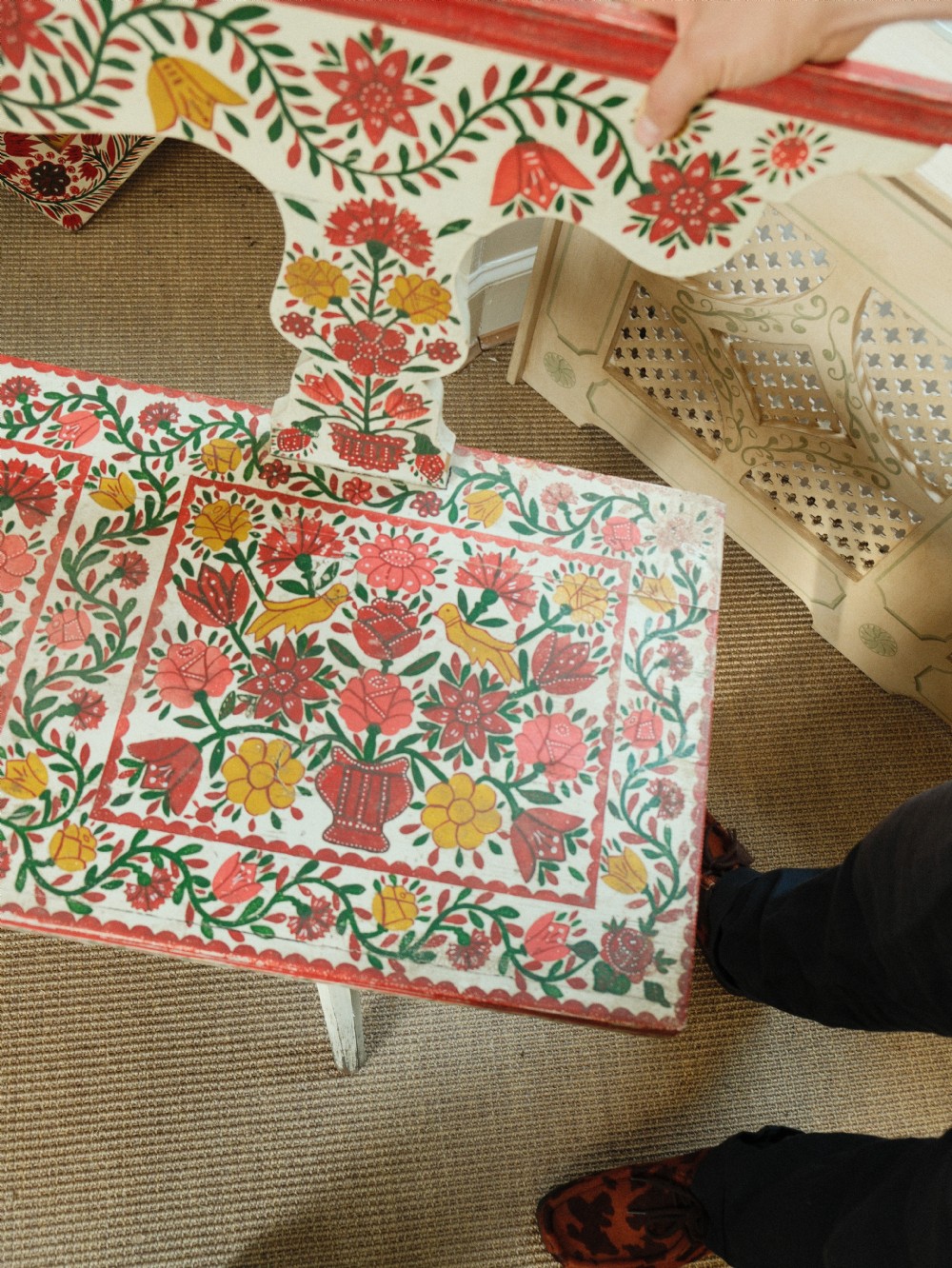 A long hand-painted wooden bench decorated with red, yellow, and green floral patterns across its seat, scalloped backrest, and front apron. View IX