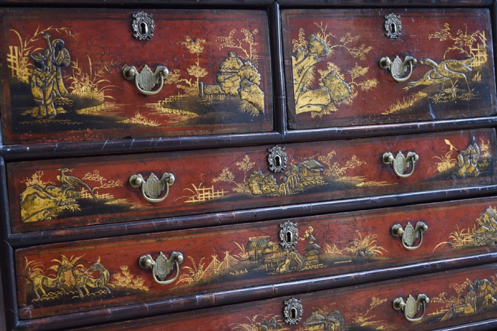 A Georgian red japanned chest of drawers decorated with gilt chinoiserie landscapes and fitted with brass drop handles. View II