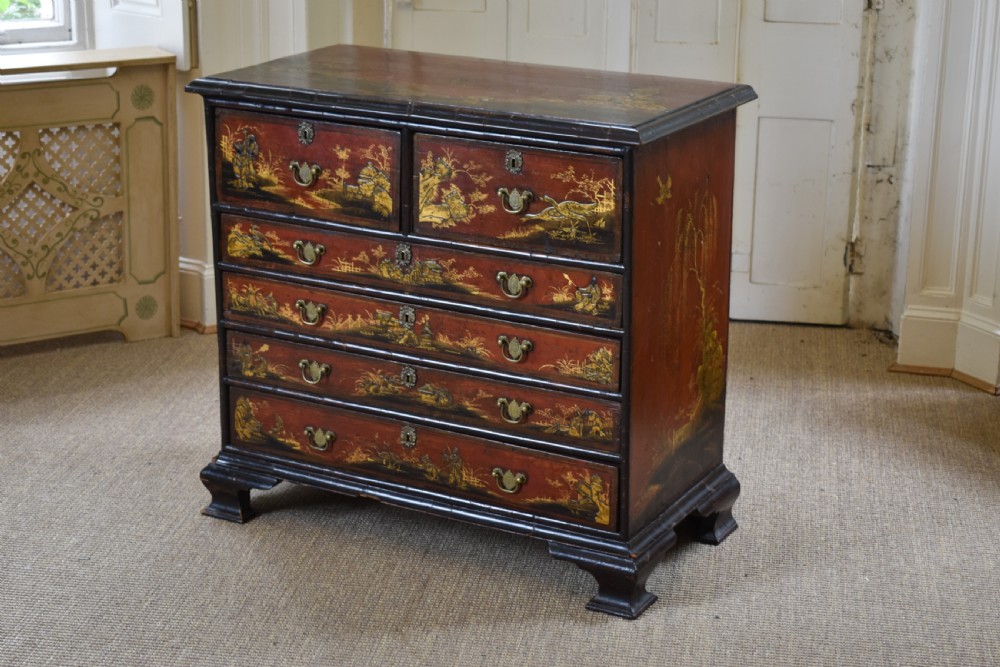 A Georgian red japanned chest of drawers decorated with gilt chinoiserie landscapes and fitted with brass drop handles. View III