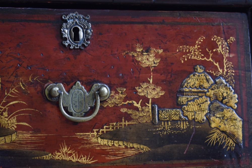 A Georgian red japanned chest of drawers decorated with gilt chinoiserie landscapes and fitted with brass drop handles. View IV