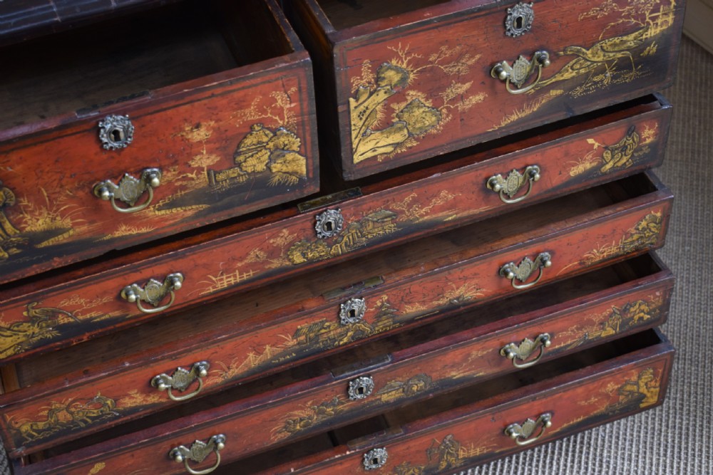 A Georgian red japanned chest of drawers decorated with gilt chinoiserie landscapes and fitted with brass drop handles. View VI