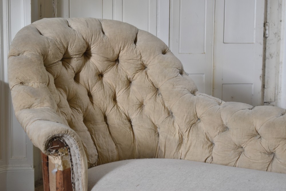 A Victorian upholstered chaise longue with deep-buttoned backrest, carved mahogany frame, and castors on cabriole legs. View II