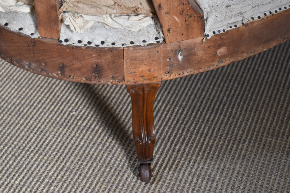 A Victorian upholstered chaise longue with deep-buttoned backrest, carved mahogany frame, and castors on cabriole legs. View III