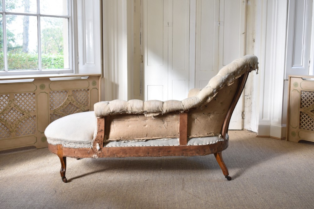 A Victorian upholstered chaise longue with deep-buttoned backrest, carved mahogany frame, and castors on cabriole legs. View VI