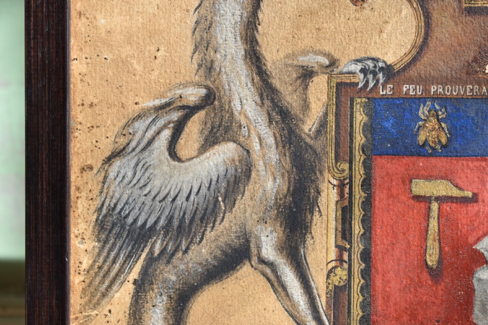 A framed 18th-century heraldic artwork displaying a central coat of arms with anvil motifs flanked by two heraldic griffin supporters. View III