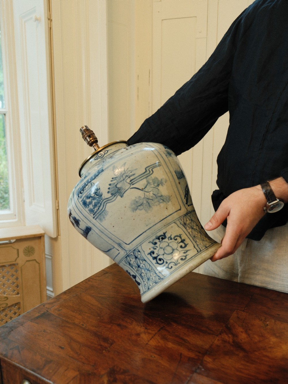 A Chinese blue and white ceramic baluster vase fitted as a table lamp with a navy and gold pleated patterned fabric shade. View III