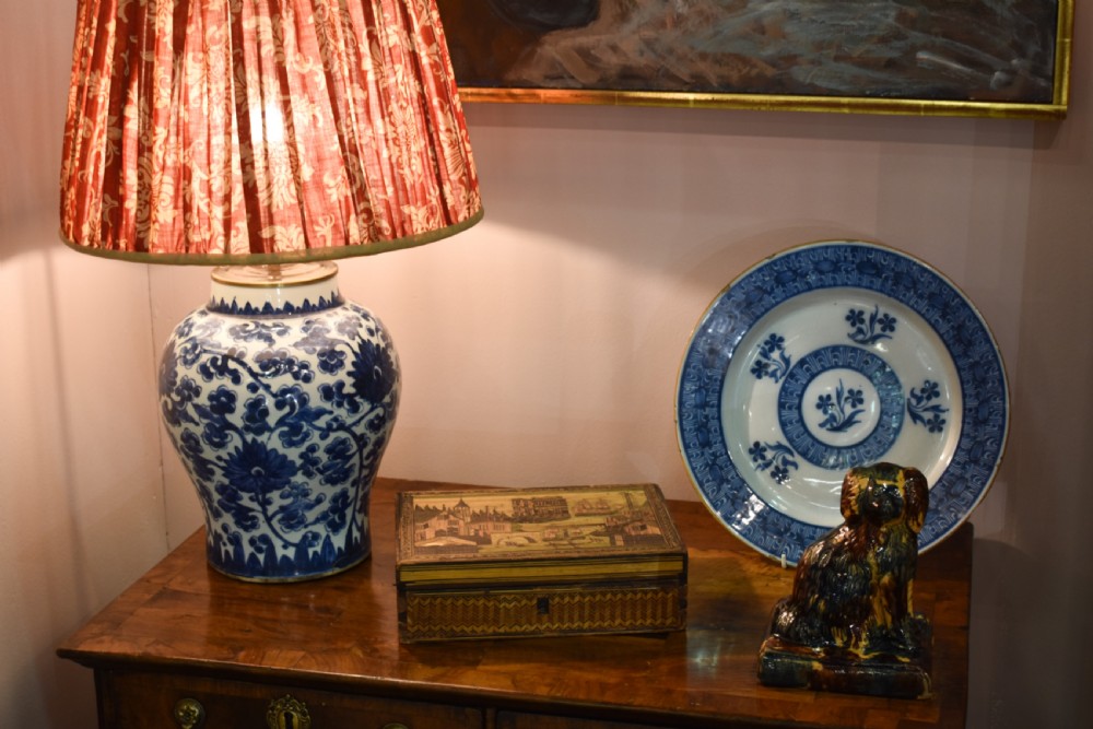 A Chinese blue and white hand-painted porcelain vase adapted as a table lamp with a pleated red floral patterned shade. View II