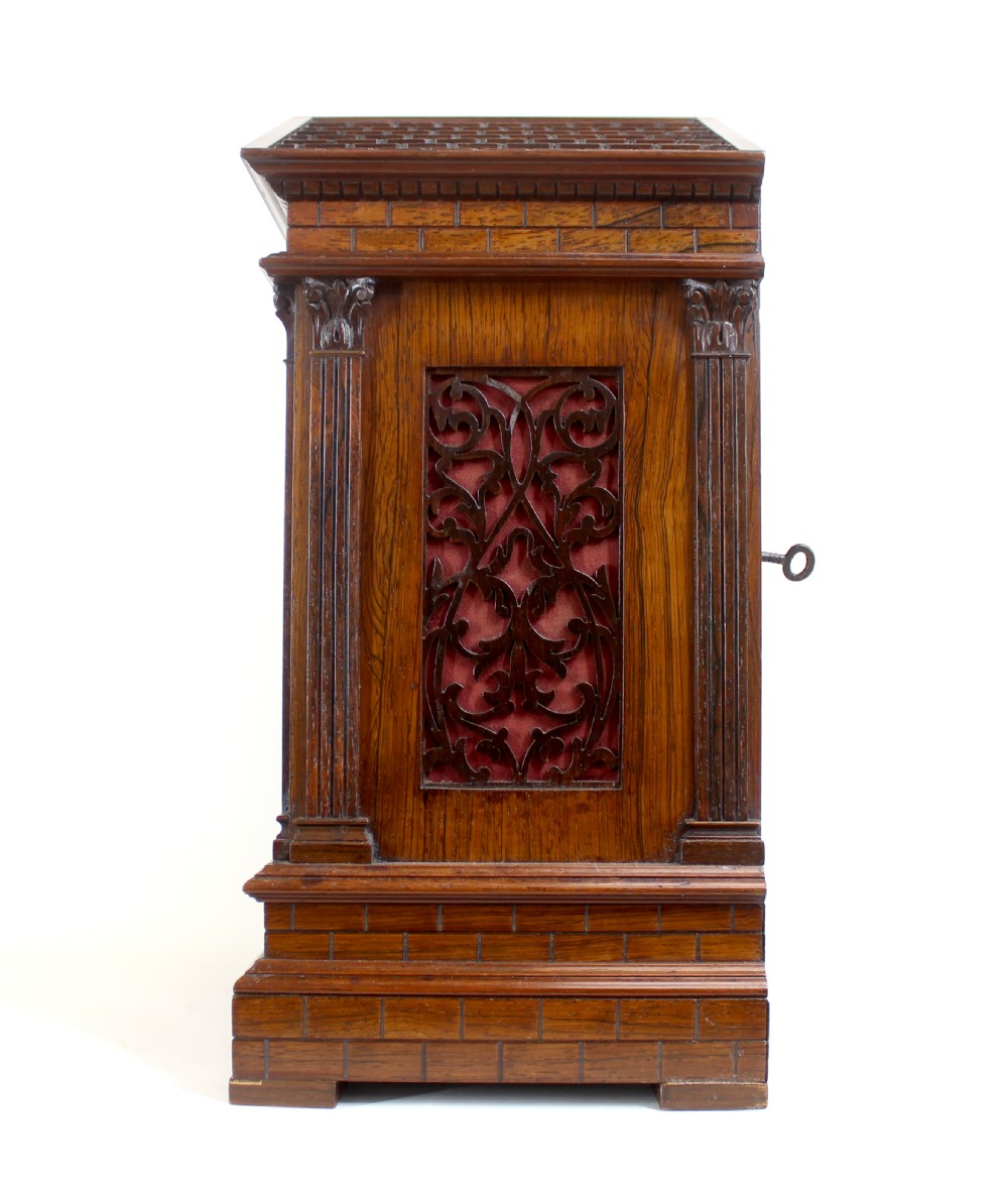 An antique rosewood architectural bracket clock featuring a pediment roof with a carved shell motif, fluted columns, and an engraved silvered dial with Roman numerals. View II
