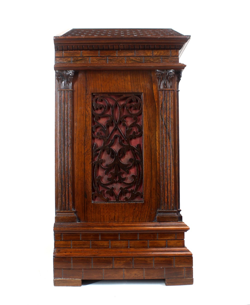 An antique rosewood architectural bracket clock featuring a pediment roof with a carved shell motif, fluted columns, and an engraved silvered dial with Roman numerals. View V