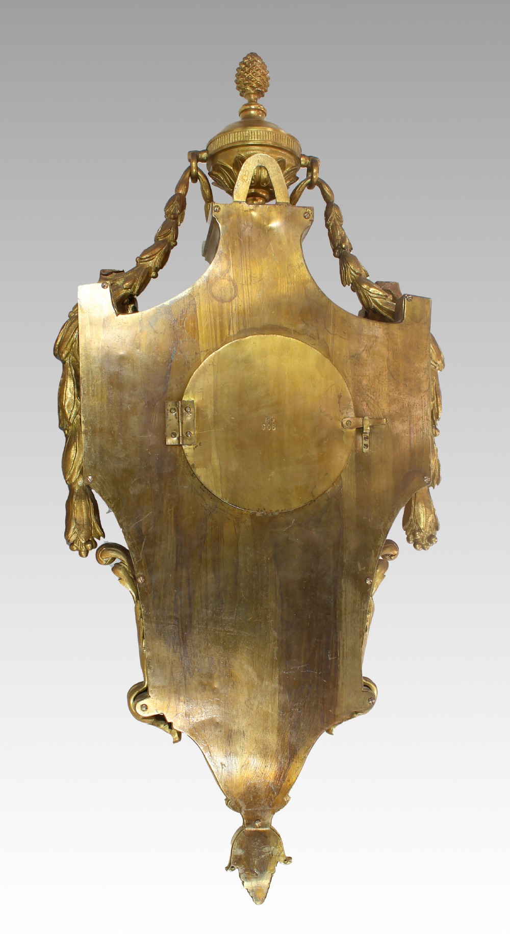 An ornate French gilt bronze cartel wall clock topped with a classical urn finial and decorated with sculpted garlands and a pink lattice panel. View II